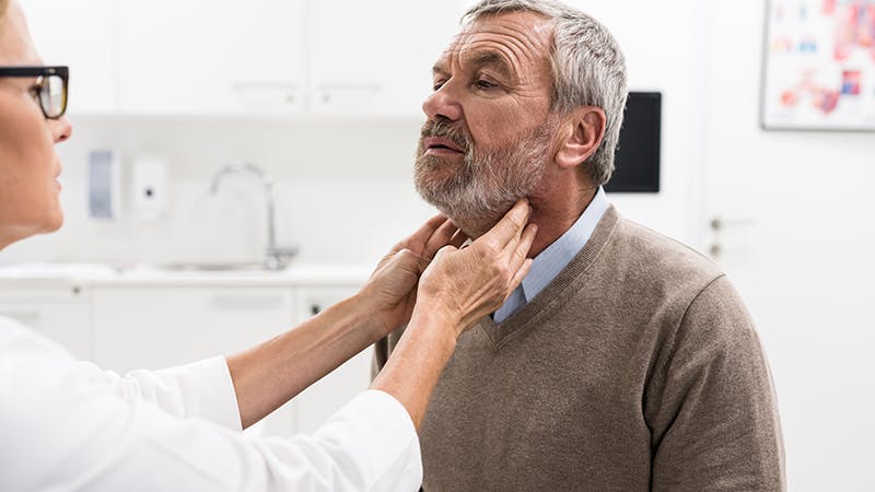 Man receiving an examination on his throat. 