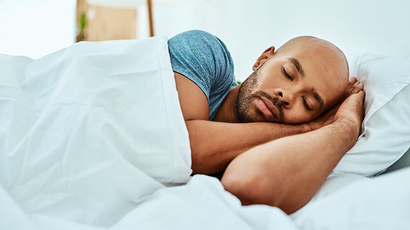 Man sleeping in bed on his side.