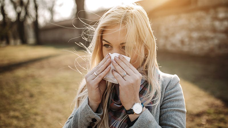 Woman blowing her nose