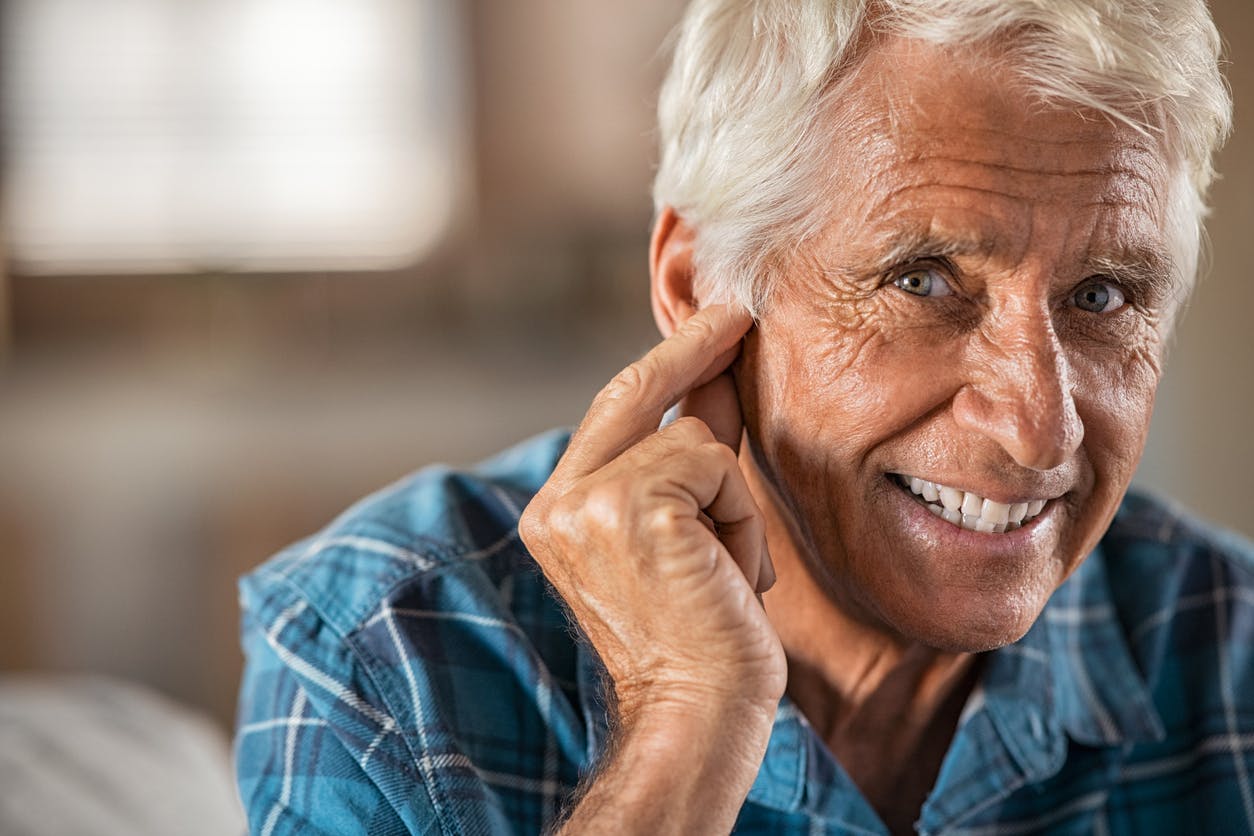 Older man pointing to ear