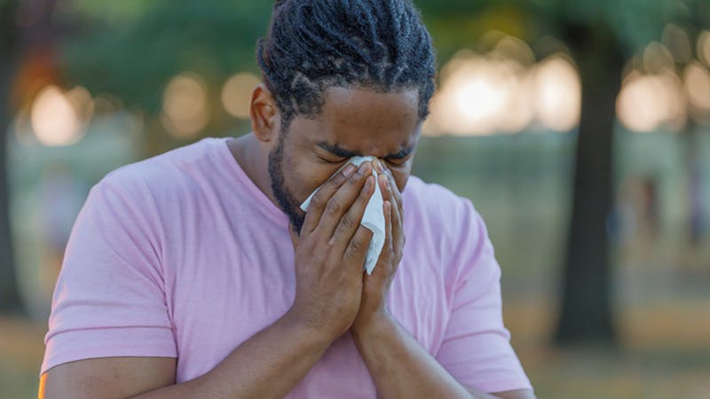 man sneezing with allergies