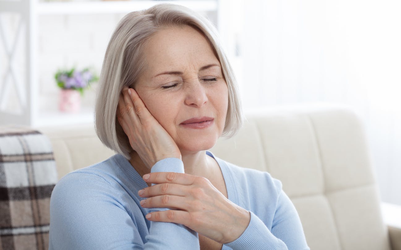 Woman holding her ear in pain