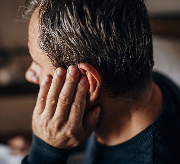 Man holding his ear