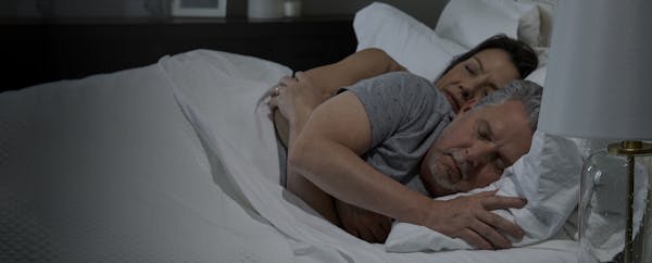 there is a man and woman sleeping in bed together