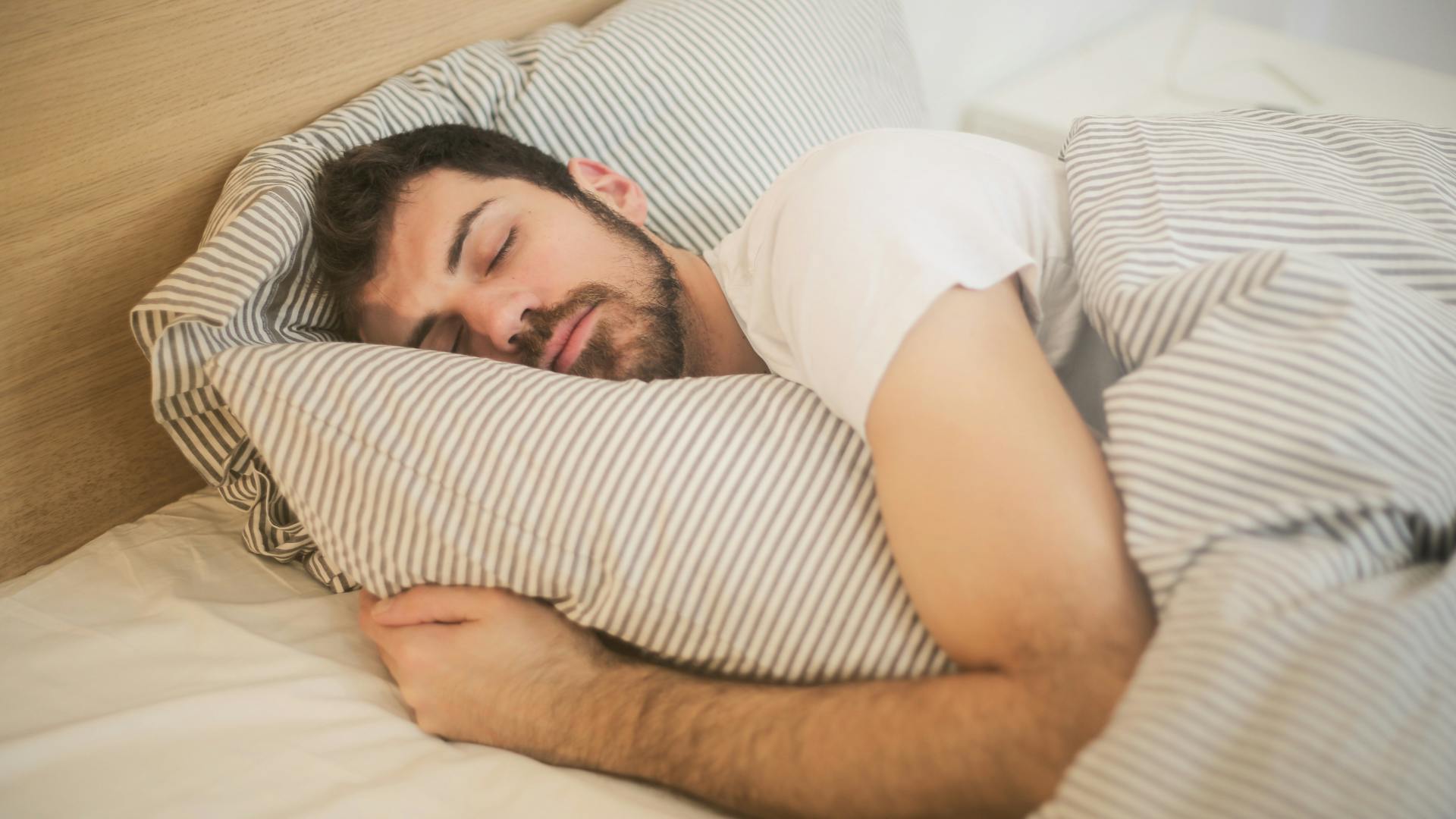 man sleeping in bed with a pillow and a pillow case