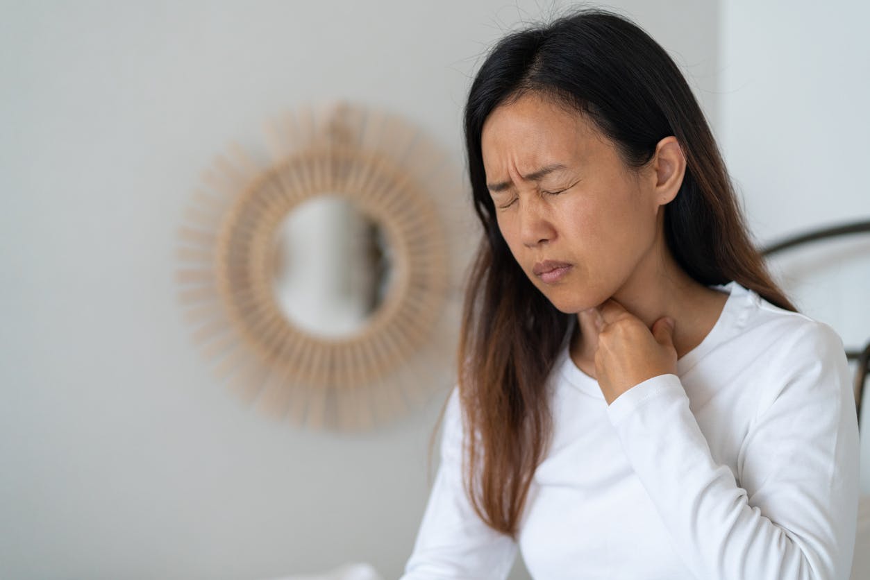 Woman touching her neck due to throat pain