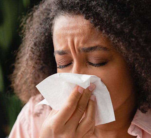 Woman blowing her nose