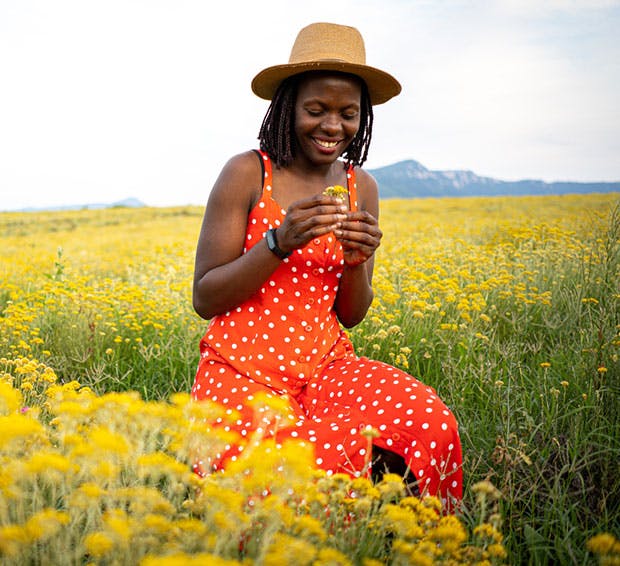 there is a woman sitting in a field of yellow flowers