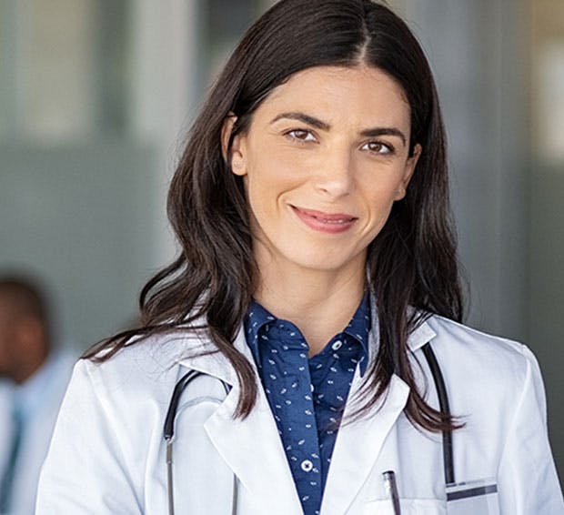 woman in a white lab coat standing in a hospital