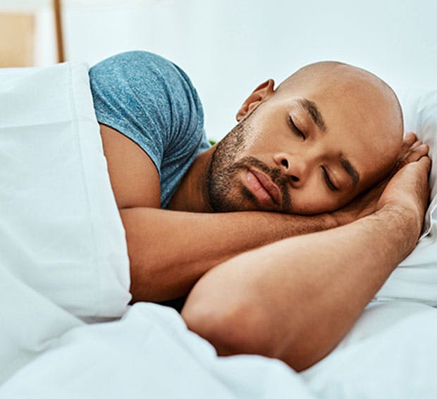 Man sleeping with his arms near his face