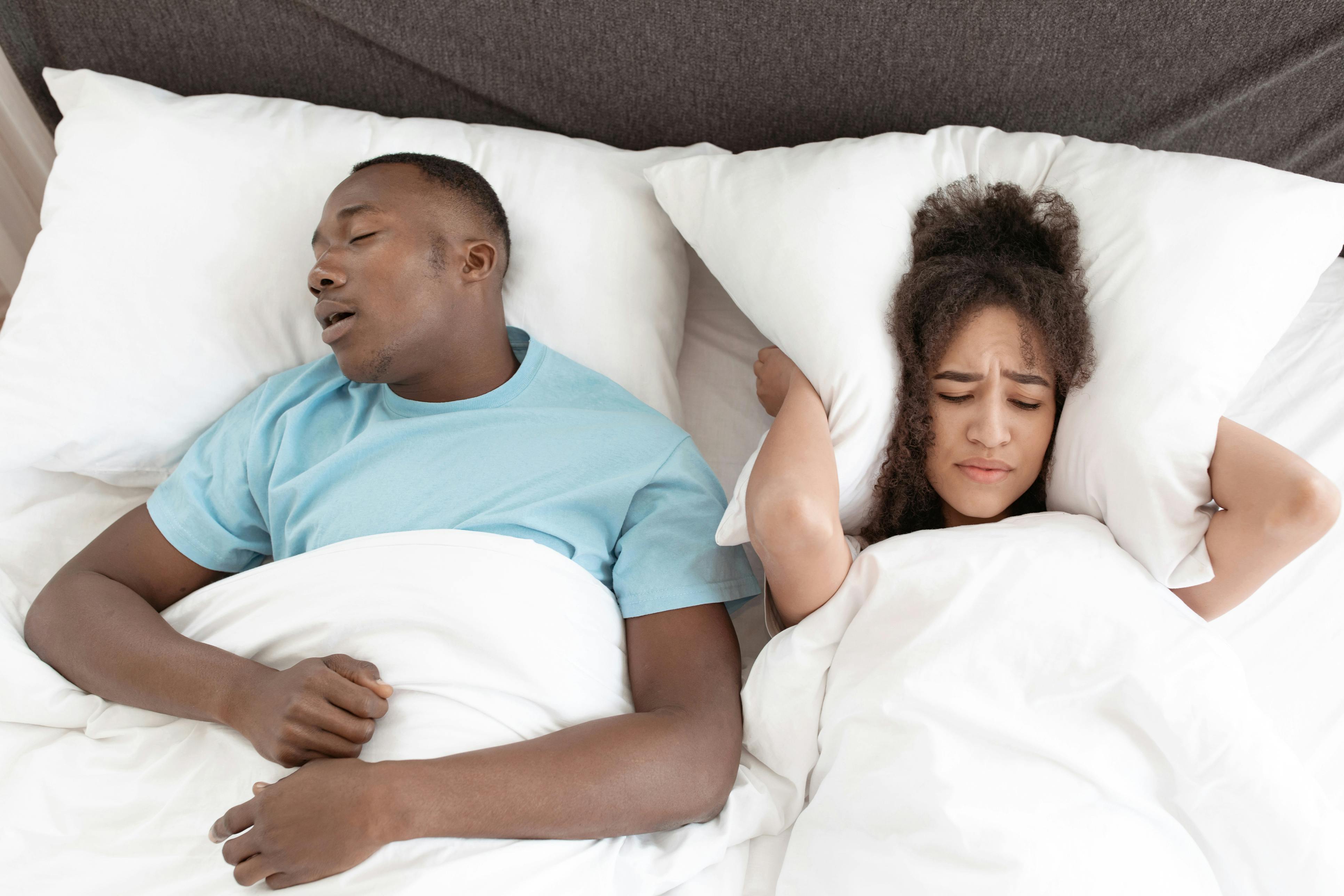 Man snoring in bed with woman