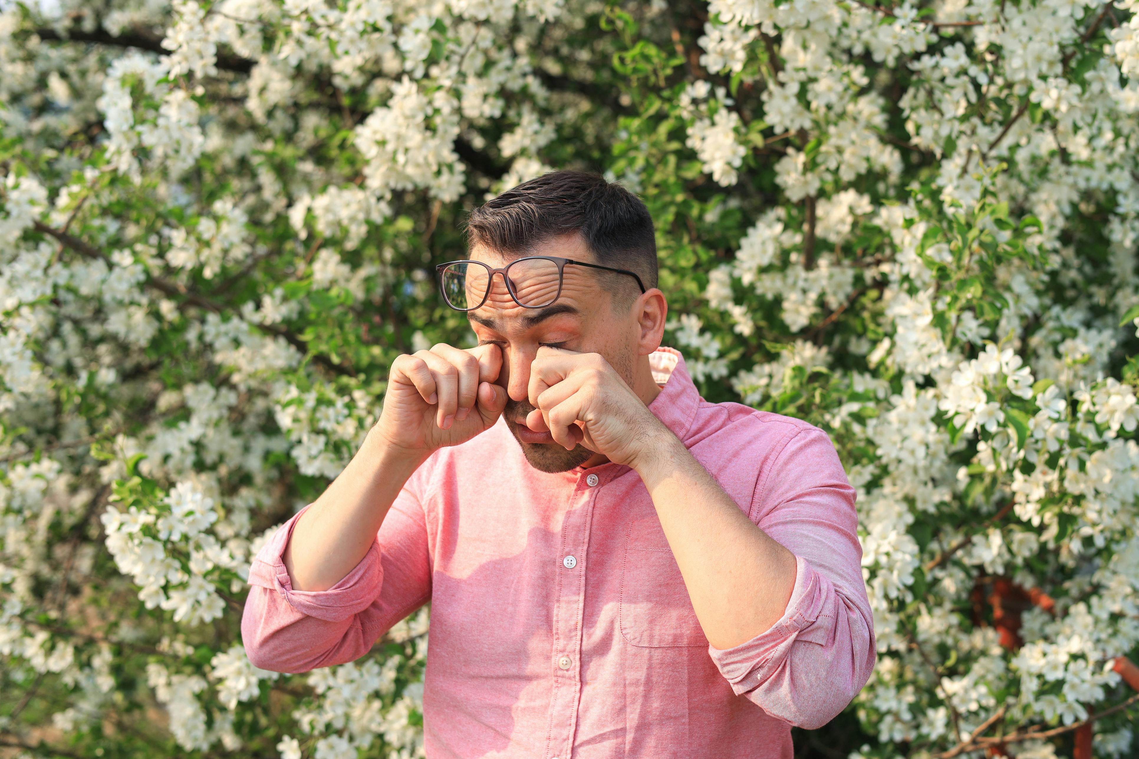 Man with watering eyes from environmental allergies