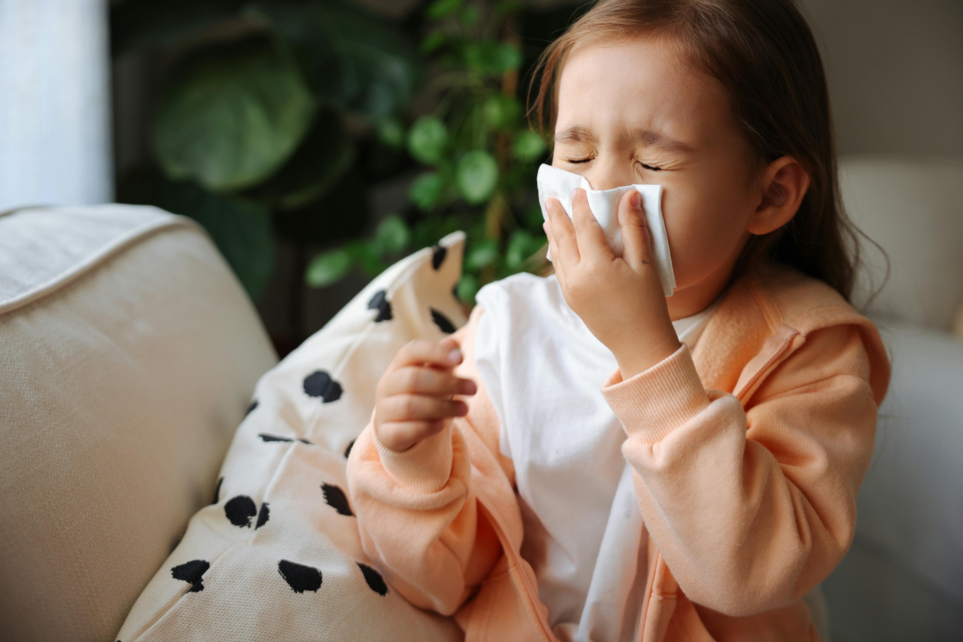 little girl blowing her nose