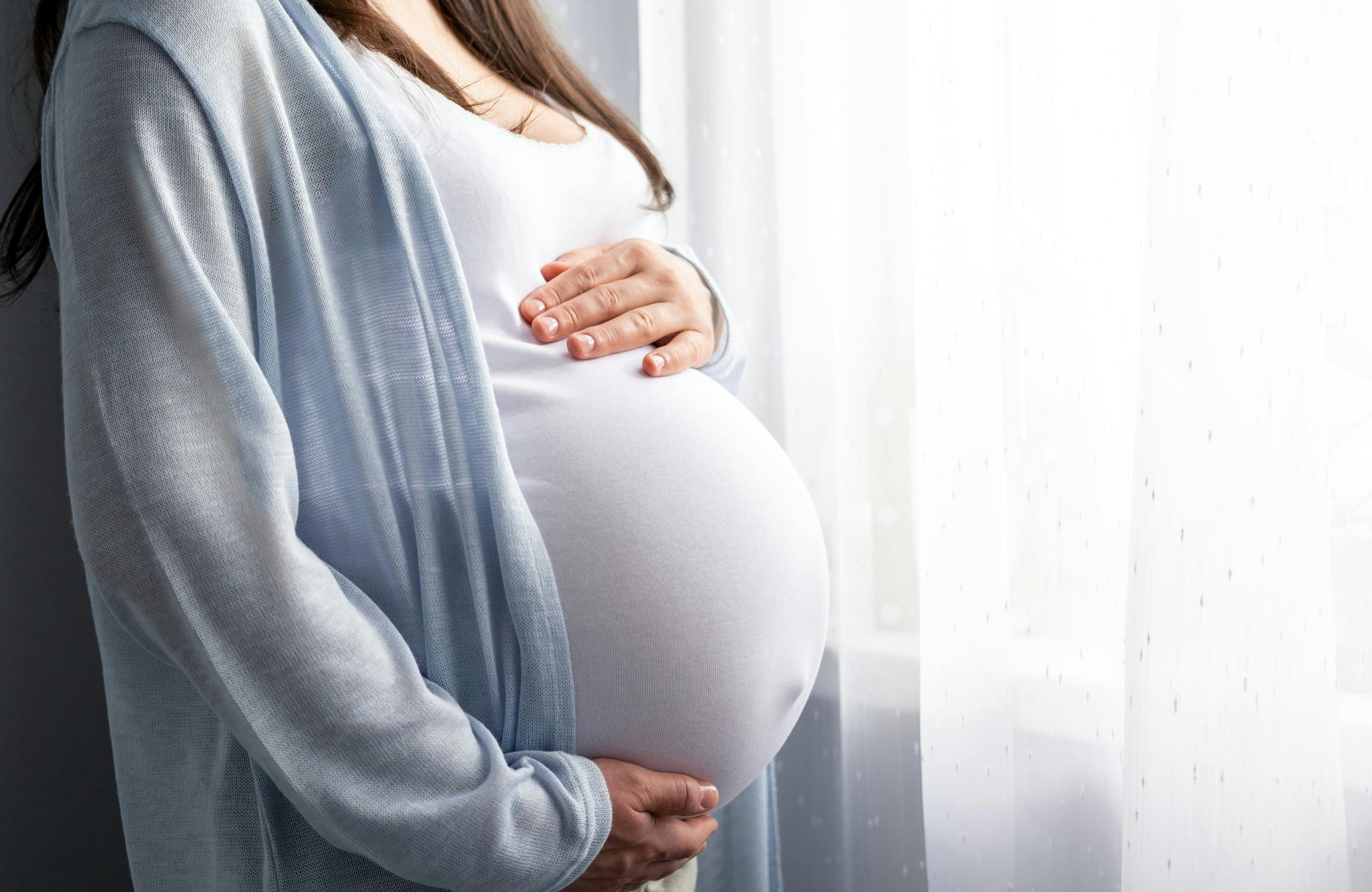 pregnant woman standing by window