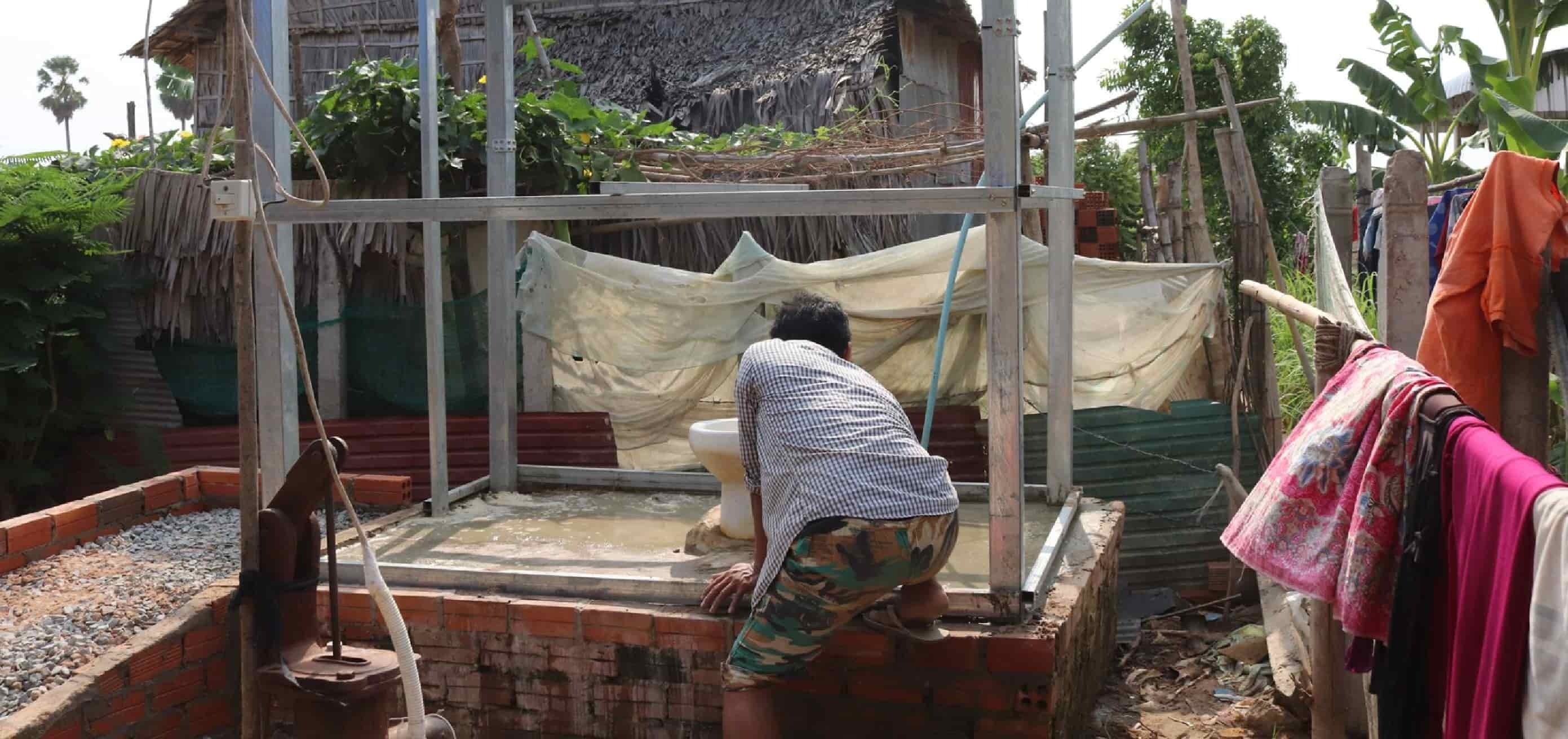 Man washing clothing outdoors in Southeast Asia