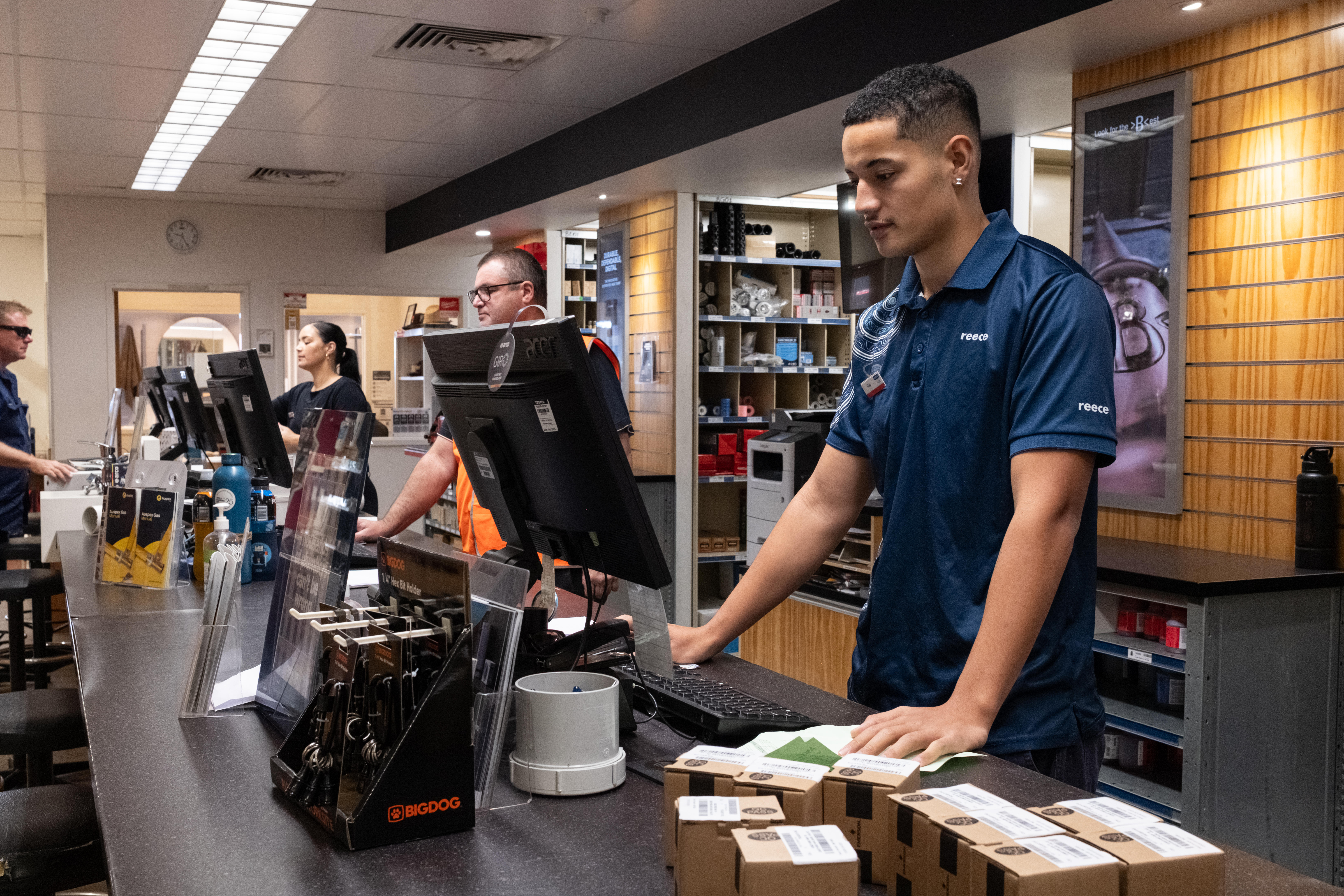 A young man works on the front of a counter at a Reece branch