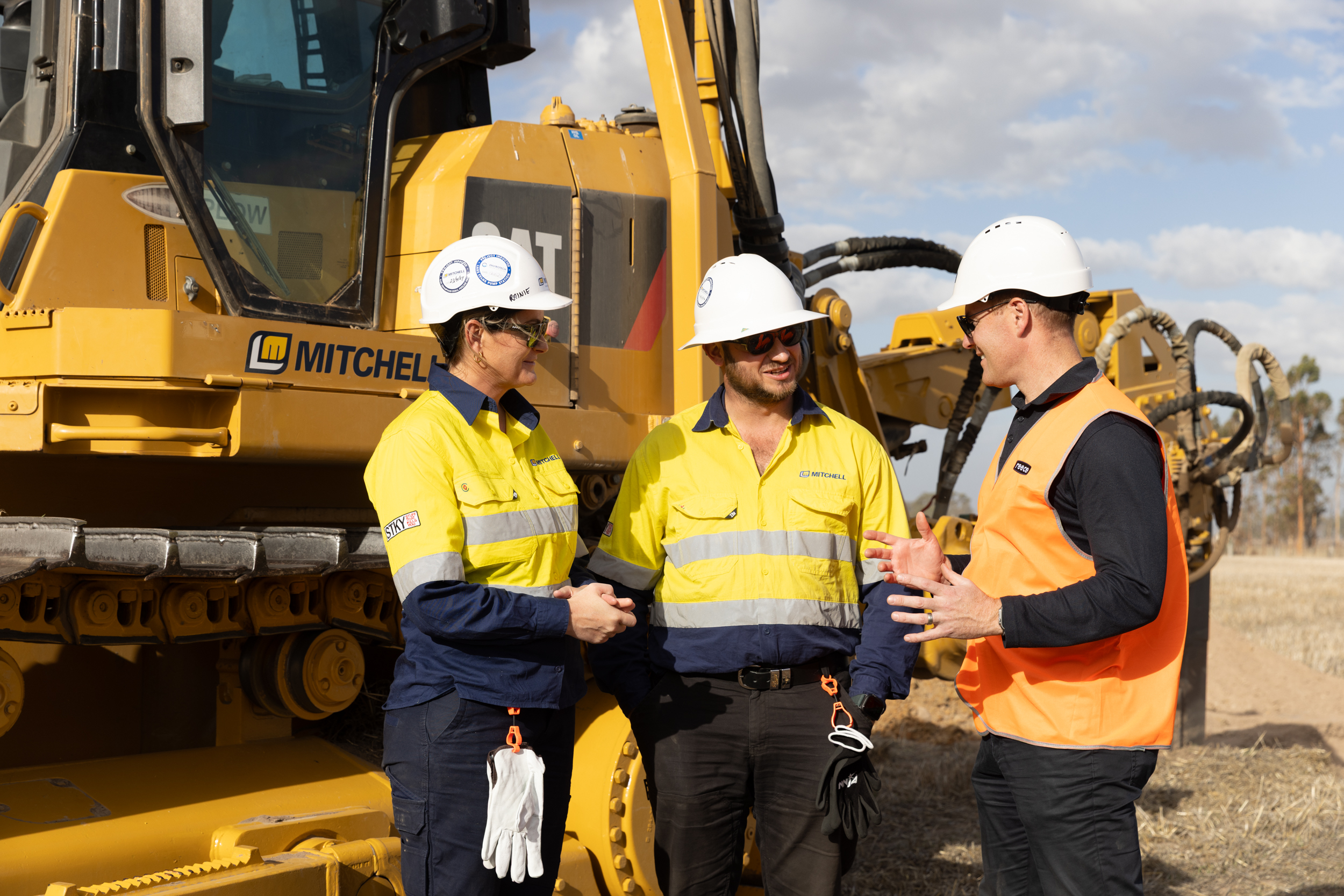 People in hi-vis around a digger