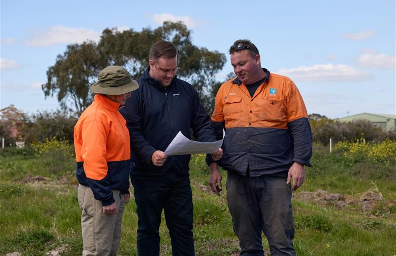 Three men looking at a plan