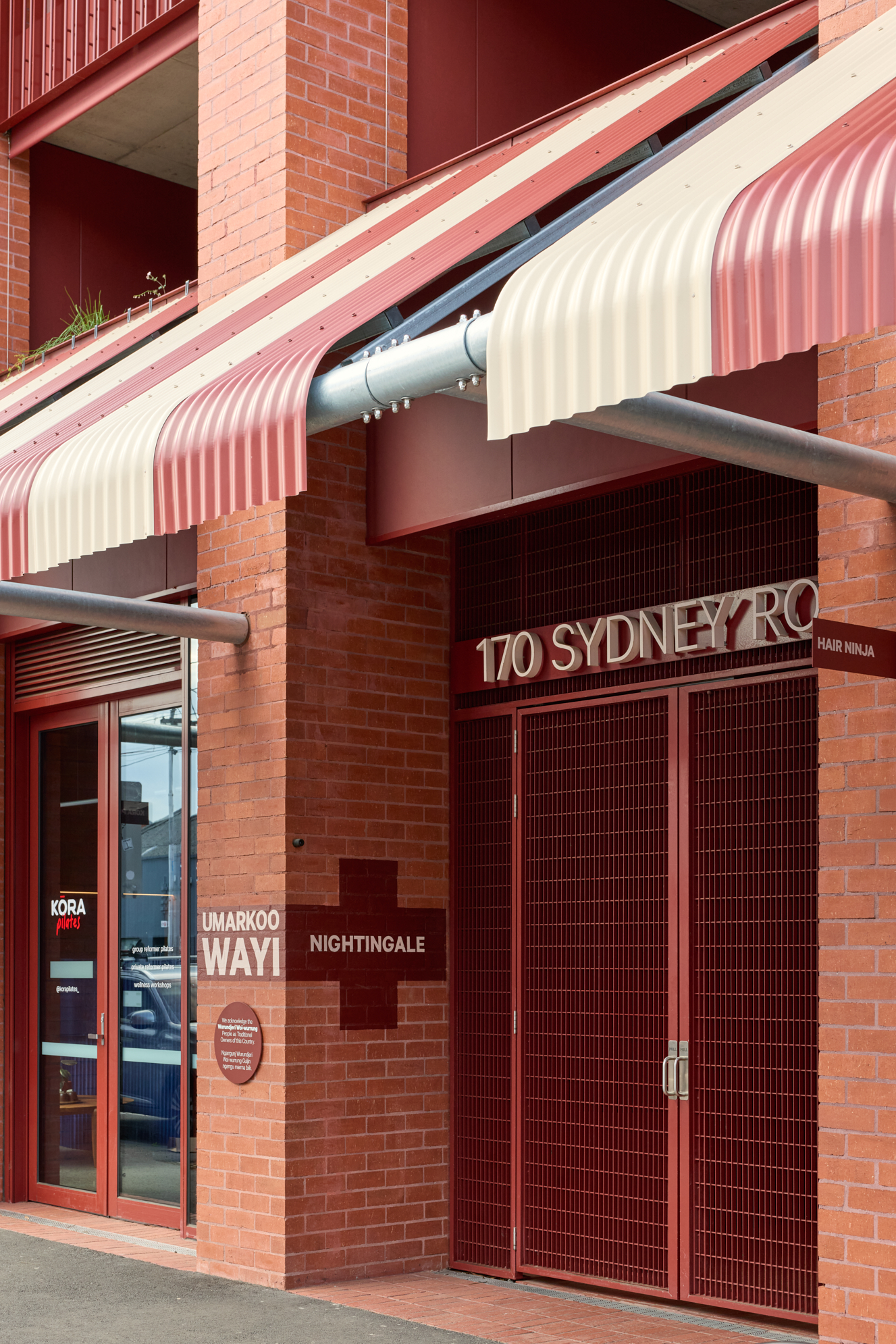 Close up of entrance - Sign above building reads 170 Sydney Road - Brick facade