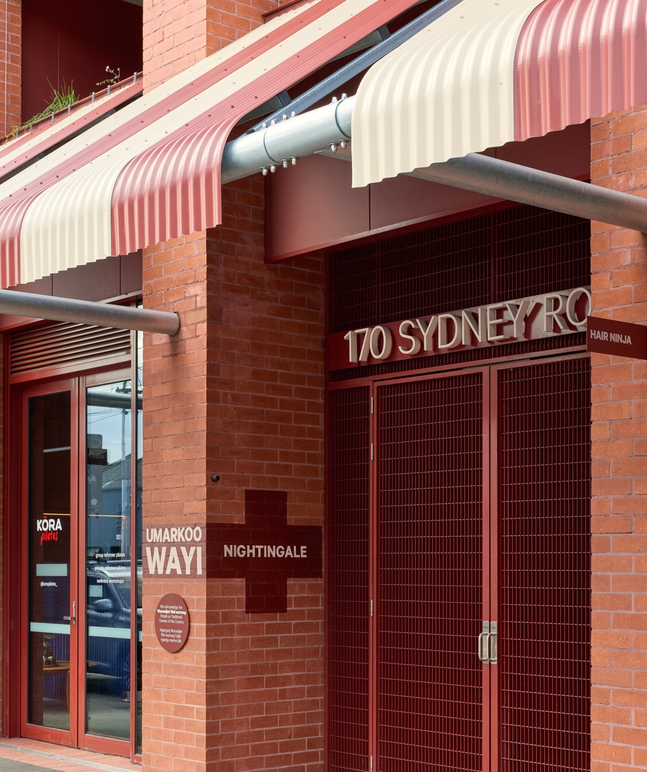 Front of building says "170 Sydney Road, Nightingale Umarkoo Wayi", brick facade