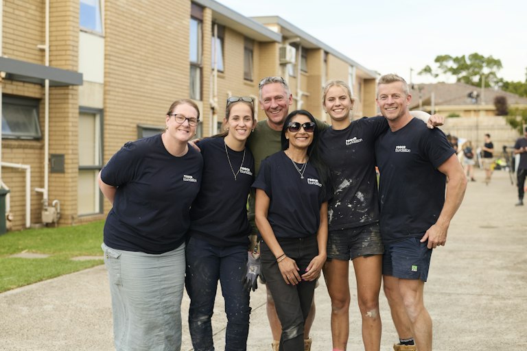 A group of volunteers standing outside the community challenge block.
