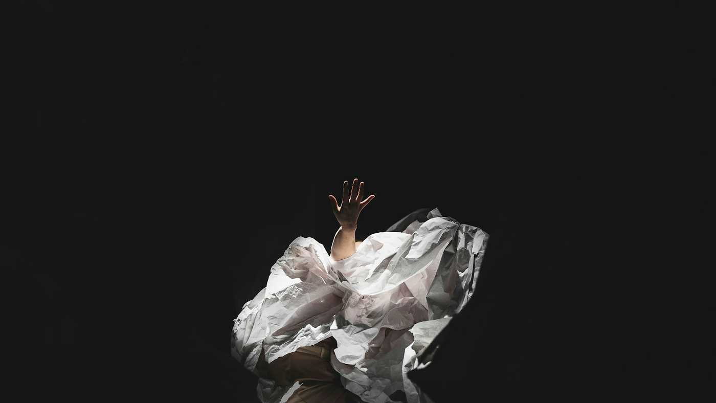 Photo du spectacle Refonte, une artiste en danse sur fond noir