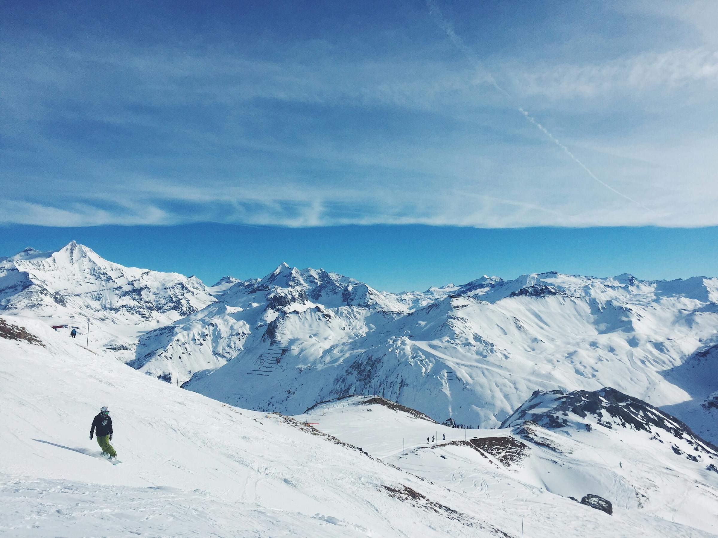 man snowboardend op een berg onder een bewolkte lucht