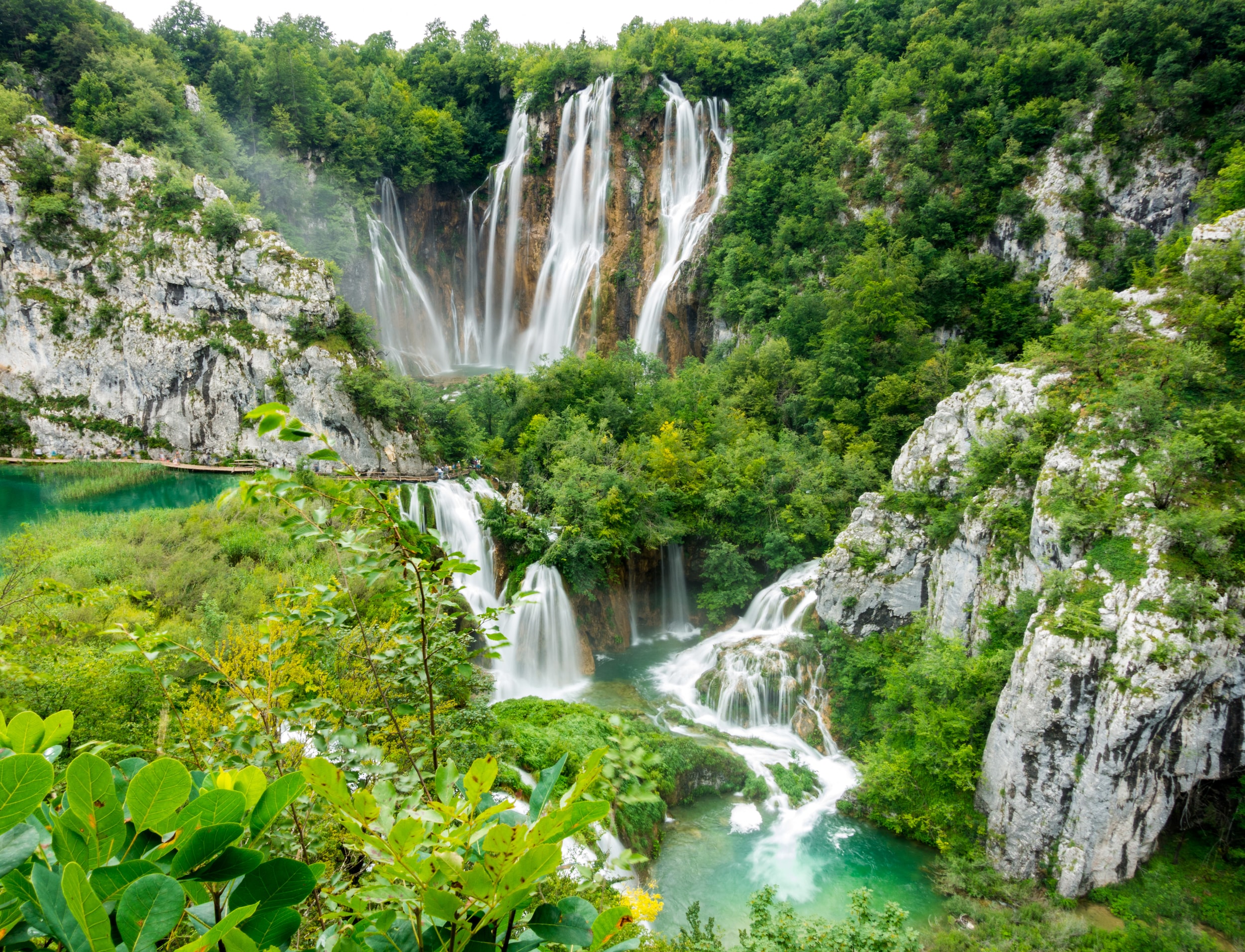 waterfalls in the middle of green trees in Plitvice Lakes National Park, in Croatia