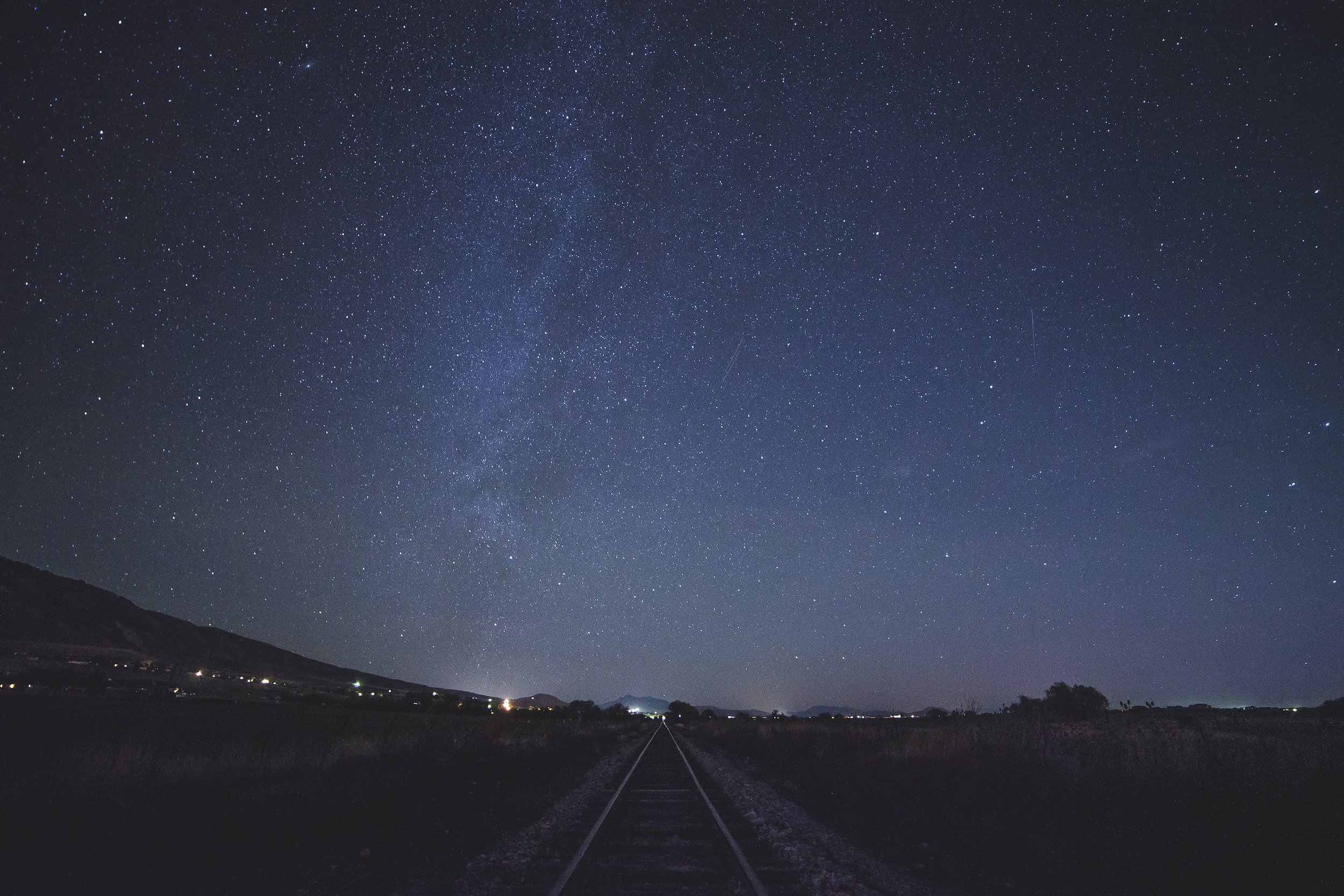 Night train holidays A starry sky at night, with a train track going into the distance