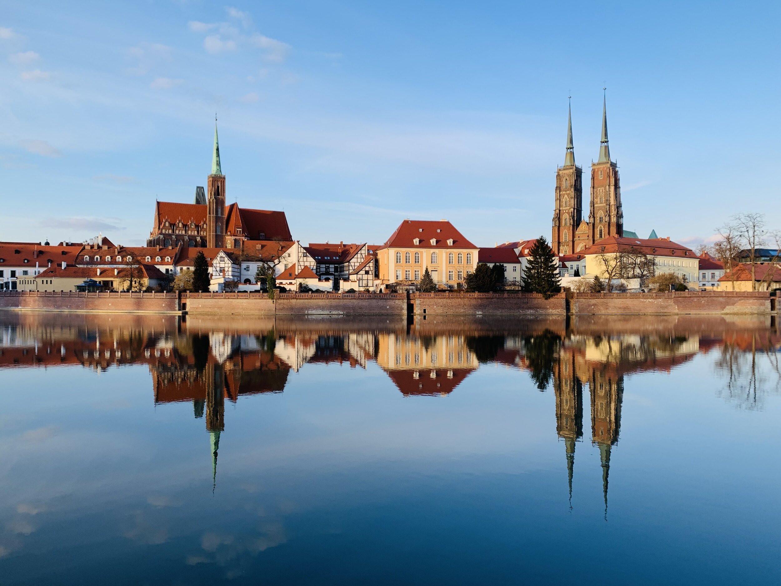 a view from the river Oder in Wroclaw, Poland, viewing red roofed houses and the cathedral on a clear day