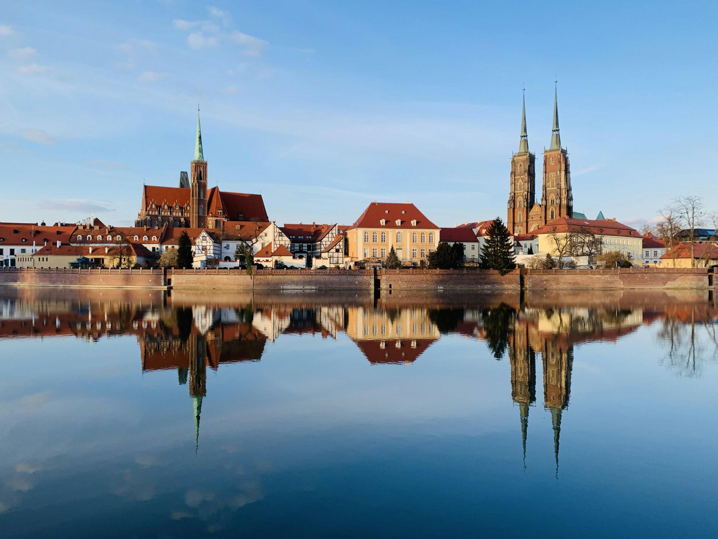 a view from the river Oder in Wroclaw, Poland, viewing red roofed houses and the cathedral on a clear day