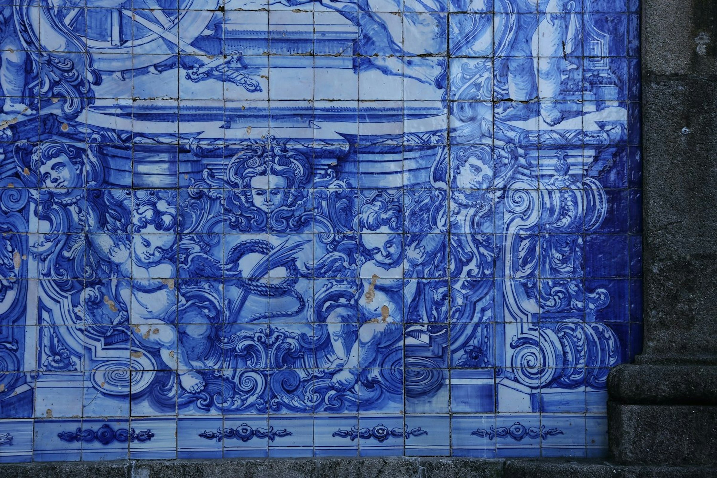Een muurschildering van blauwe en witte tegels in Portugal, die kleine engeltjes afbeeldt,