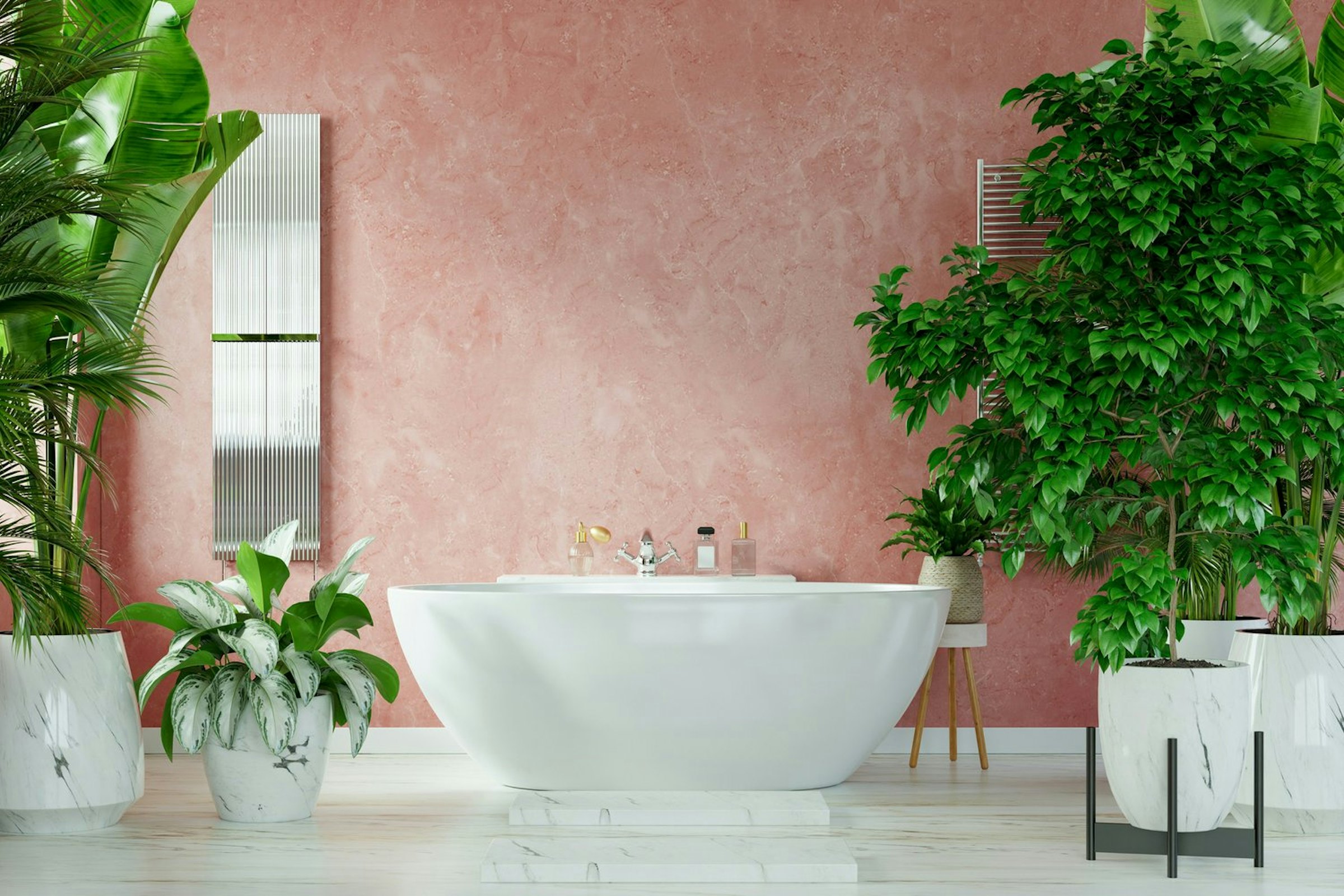A freestanding bathtub sits among lush potted plants in a pink-walled bathroom.