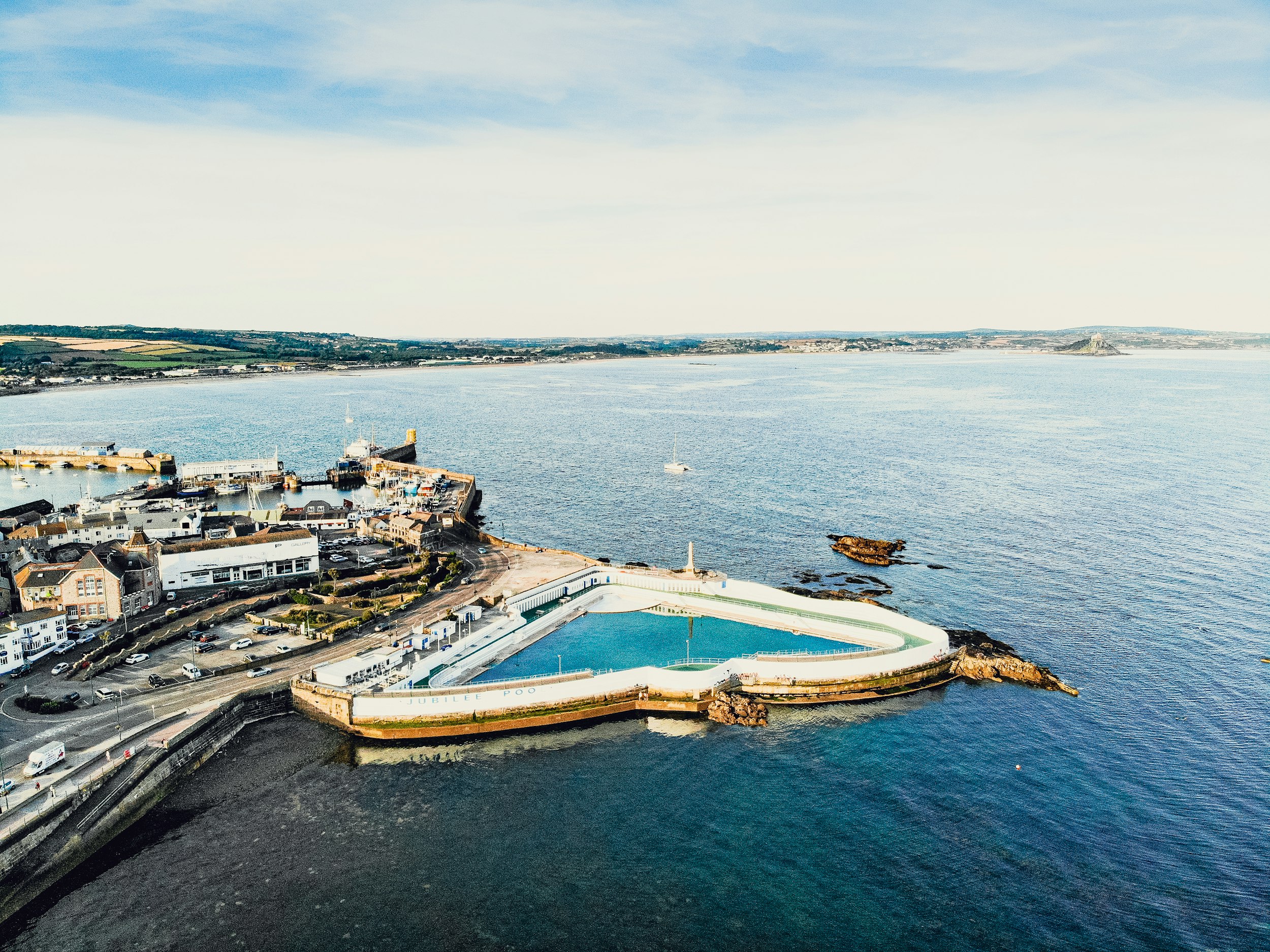 an aerial view of the sea at Penzance, Cornwall, with the famous geothermal Jubilee pool lido next to the sea