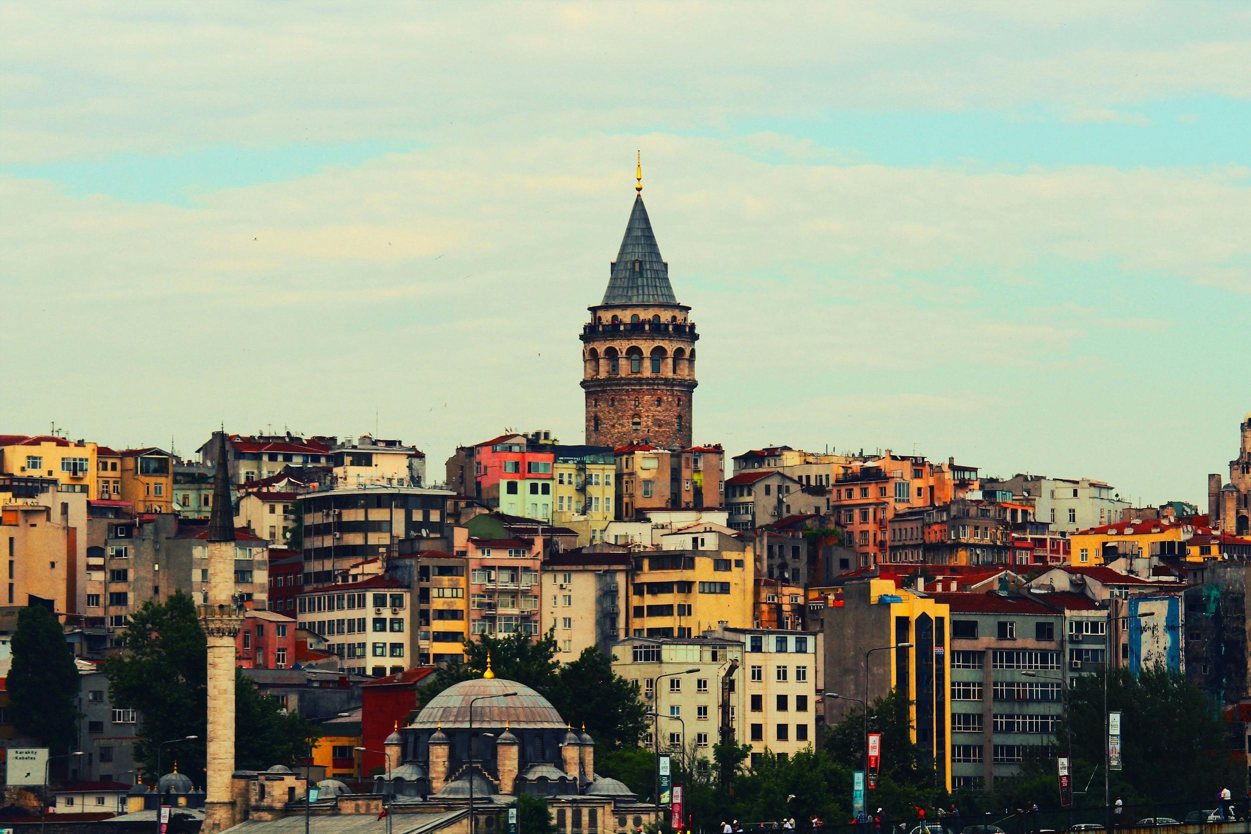 a view of the city of istanbul, with colourful buildings and a spire