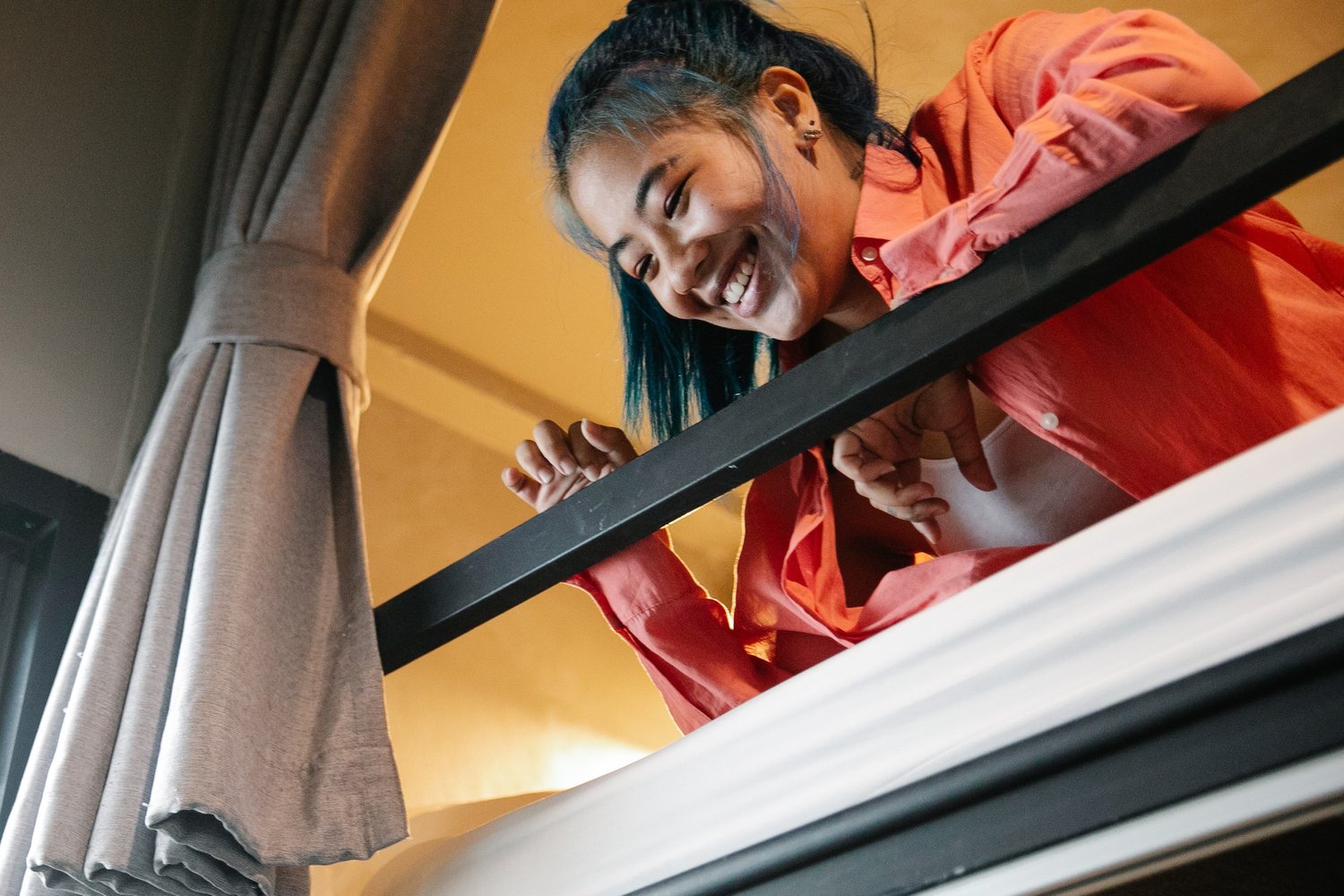 a girl looking down from her bunk bed in a sleeper train cabin