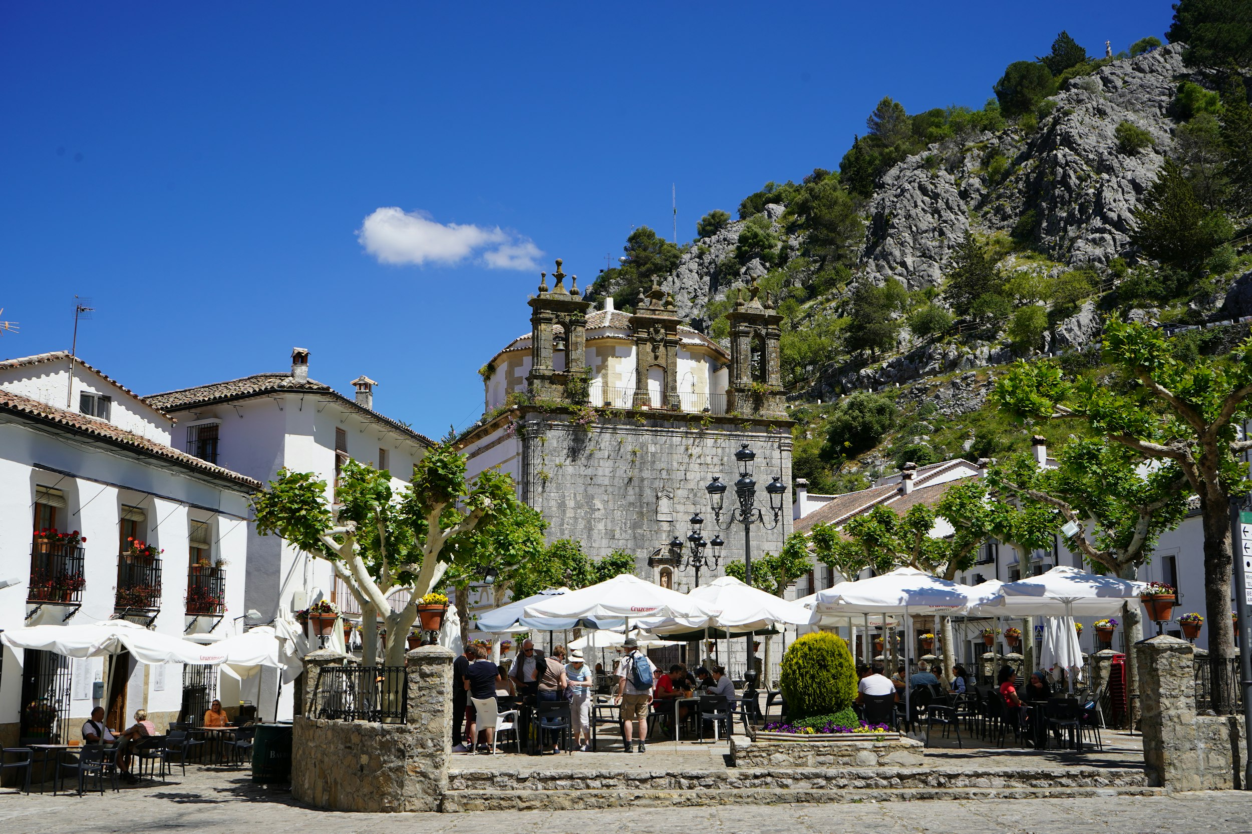 a group of people sitting at tables under umbrellas