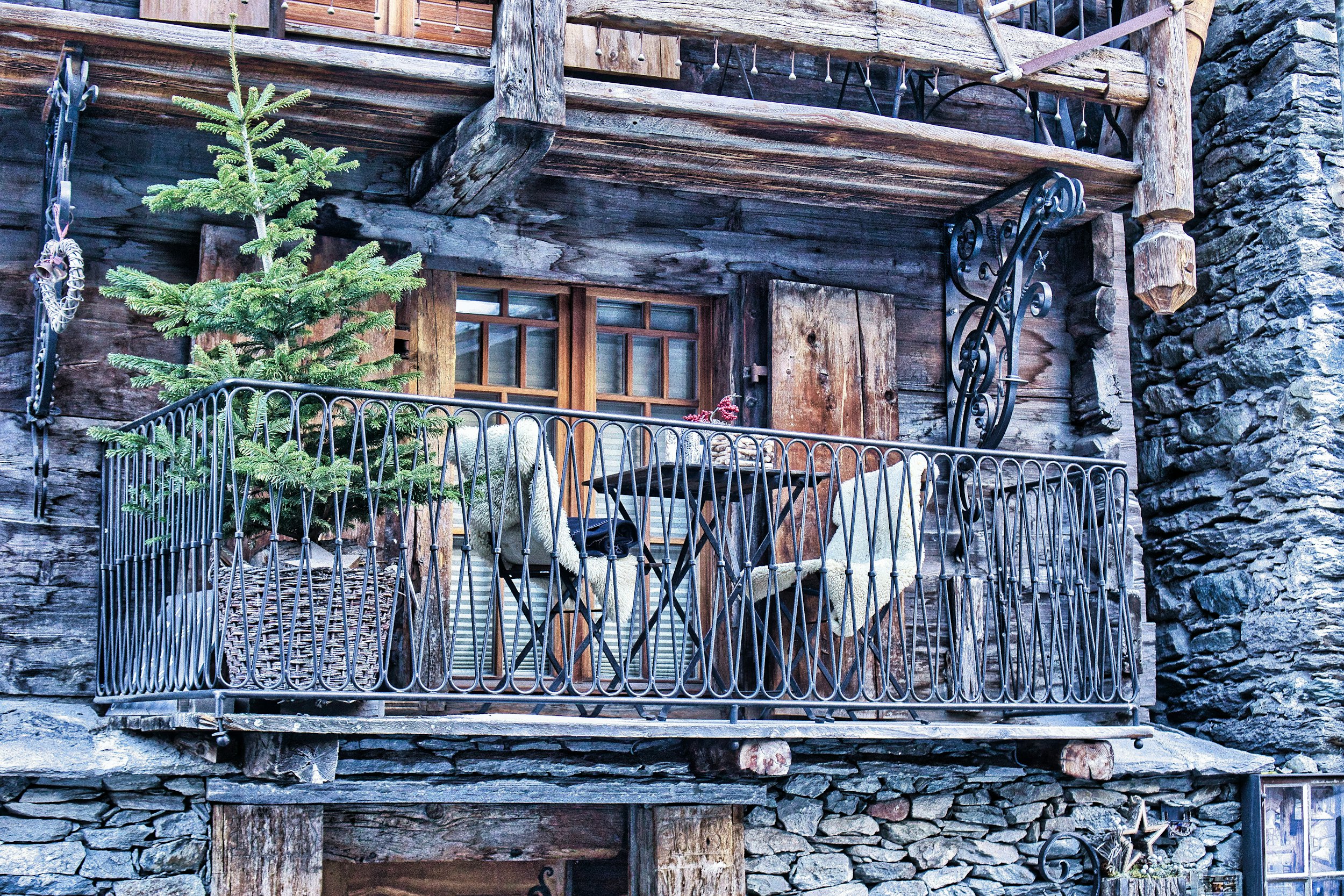 a wooden building with a balcony and iron railing