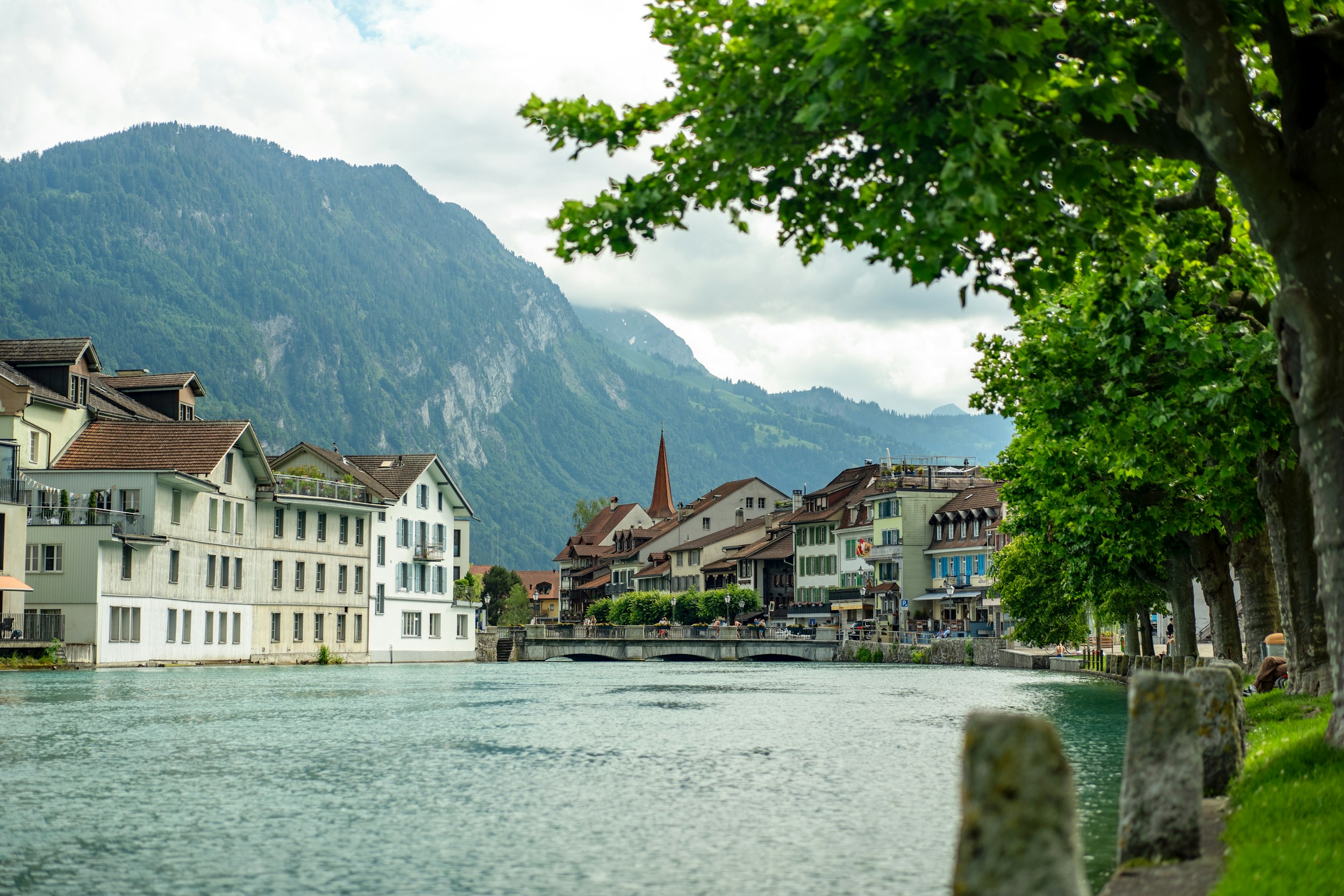 a body of water with buildings along it and mountains in the background