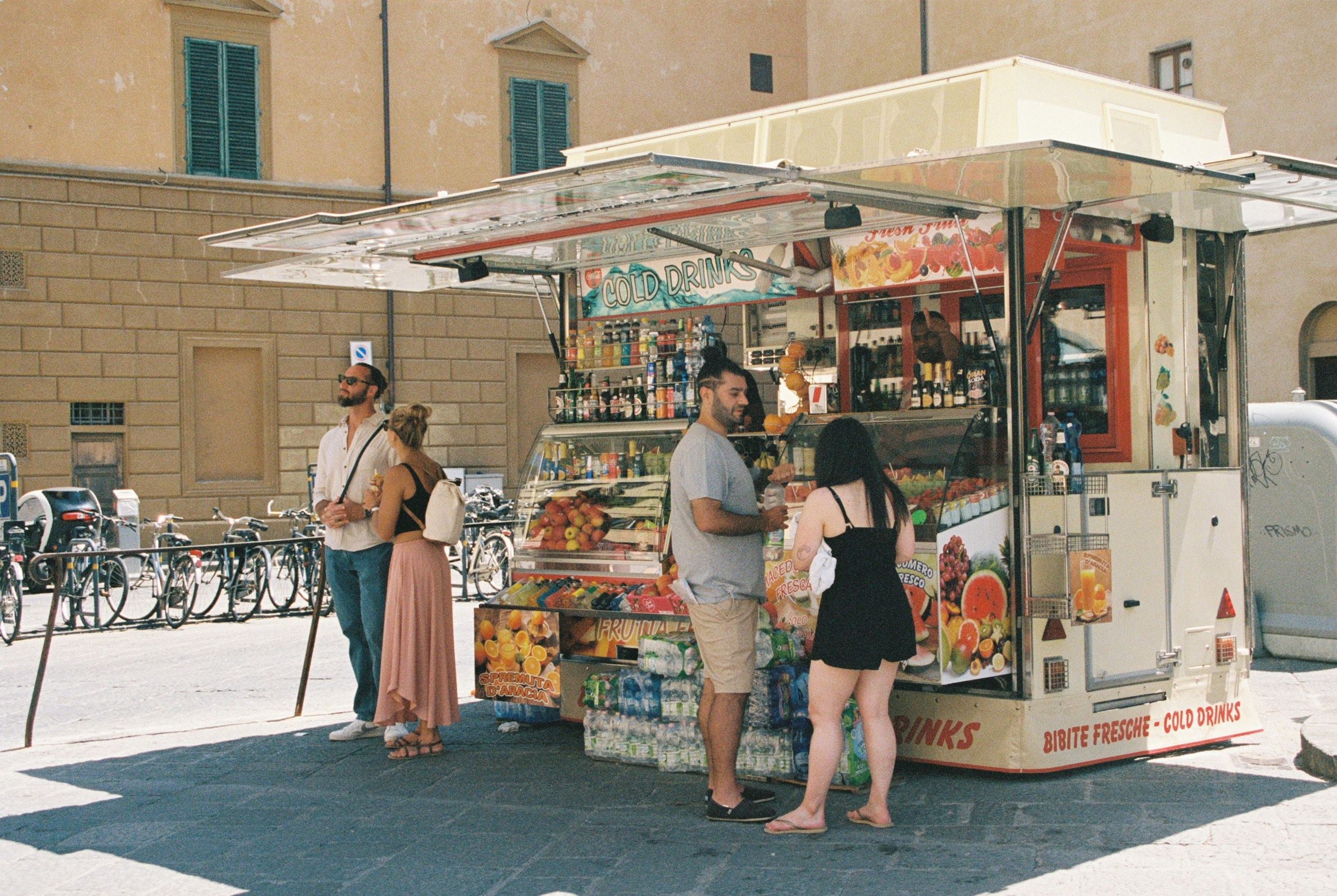 people standing outside a food stand
