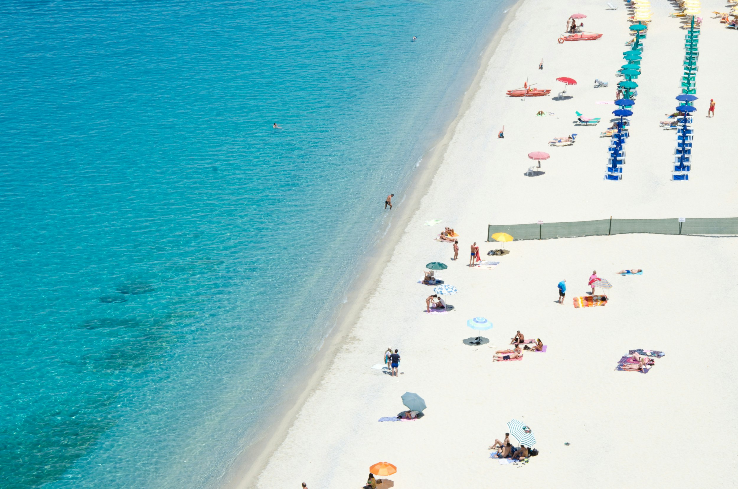 people on white sand beach high angle photo