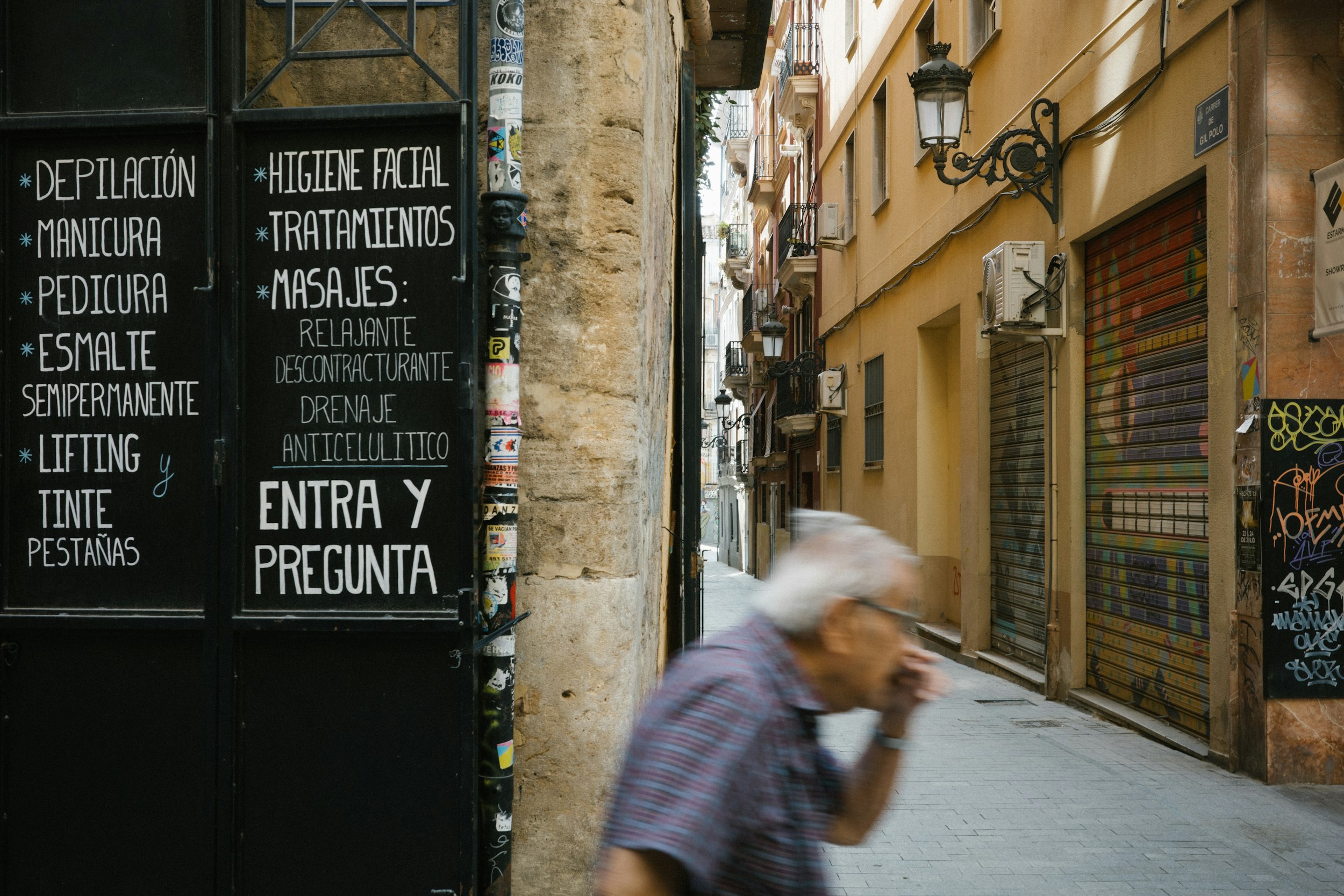 A man walking down a street talking on a cell phone