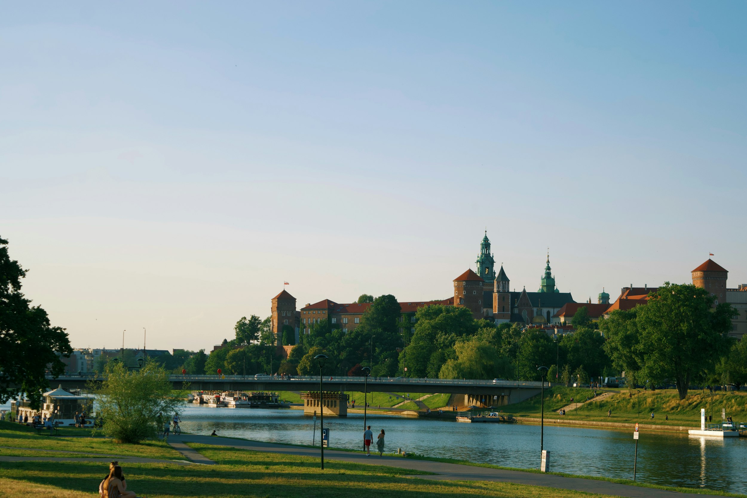 a person sitting on a bench near a river