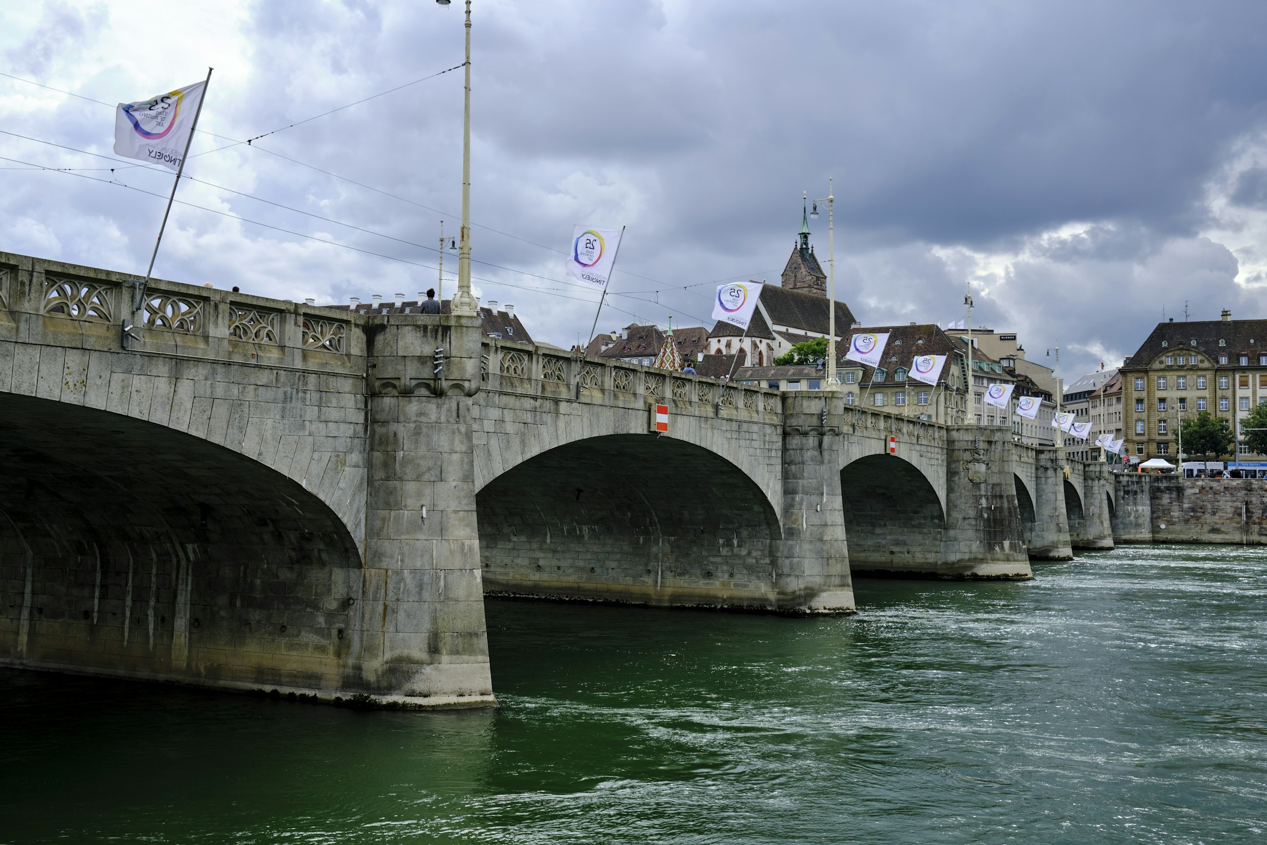 a bridge over a body of water with buildings in the background