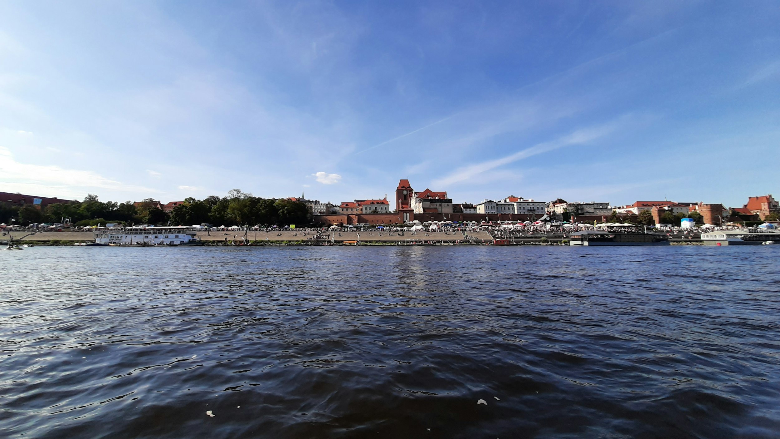 city buildings near body of water under blue sky during daytime
