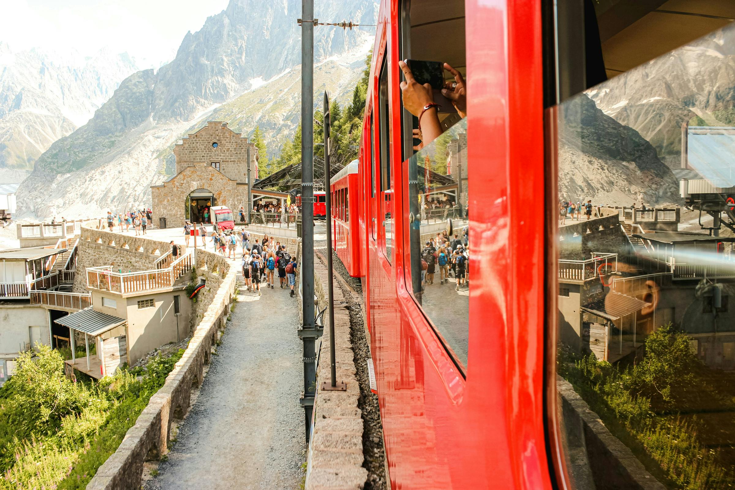 Red Montenvers train arriving at the mountain station above Chamonix, glacier peaks beyond