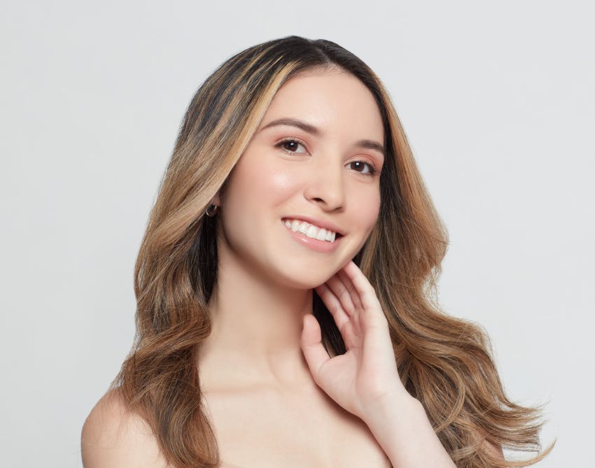 Woman with brown hair and highlights smiling