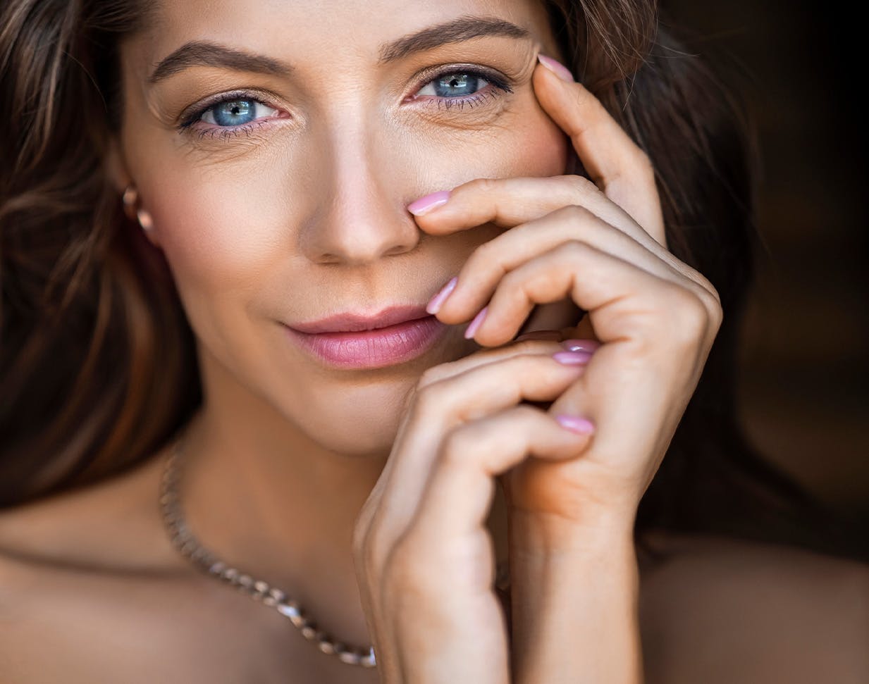 Woman with blue eyes and pink nail polish