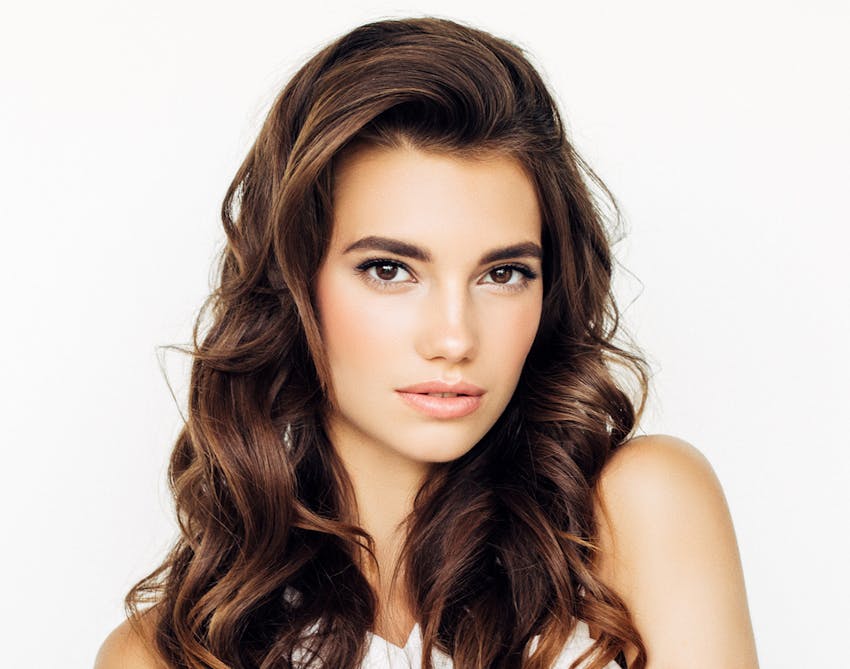 Woman with brown curled hair posing seriously