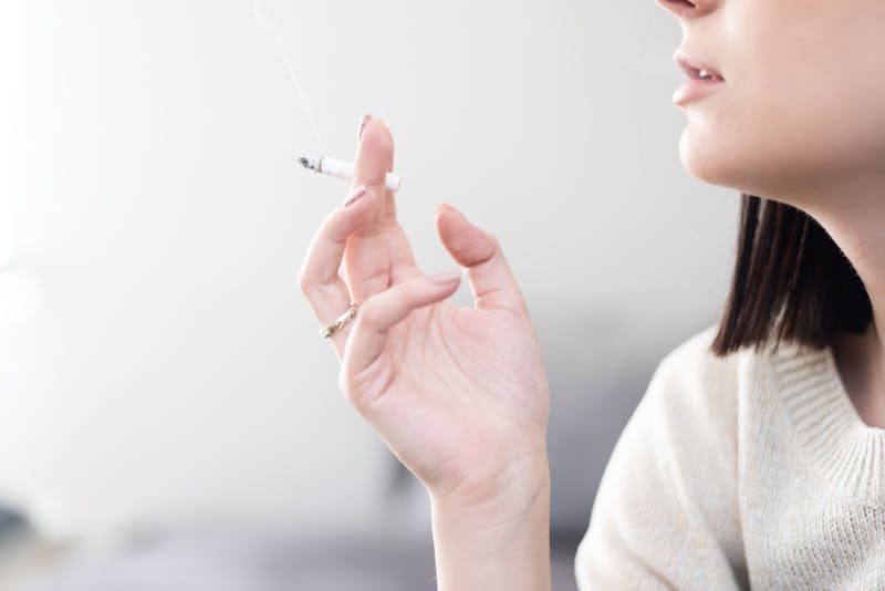 a woman holding a cigarette in her hand